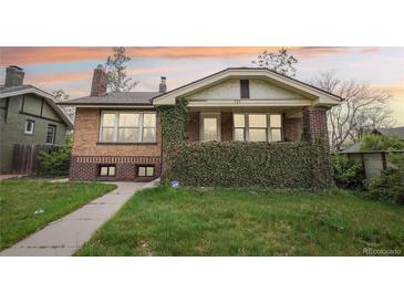 Charming brick home with lush greenery, well-manicured lawn, and inviting curb appeal at 925 S University Blvd, Denver, CO 80209
