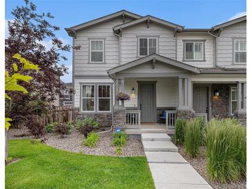 Charming two-story home featuring stone accents, well-manicured landscaping, and a welcoming front porch at 6027 N Netherland Ct, Aurora, CO 80019