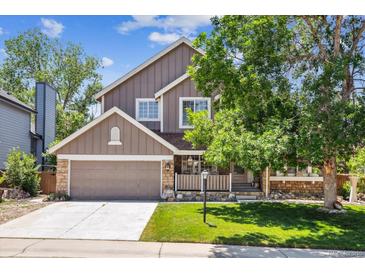 Charming two-story home featuring a well-maintained front yard with beautiful tree and a two-car garage at 1744 Brookside Dr, Highlands Ranch, CO 80126