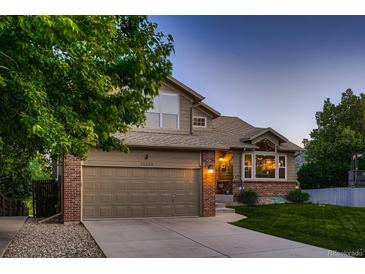 Charming two-story home with a brick and siding exterior, well-maintained lawn, and attached two-car garage at 12534 W Hoover Ave, Littleton, CO 80127