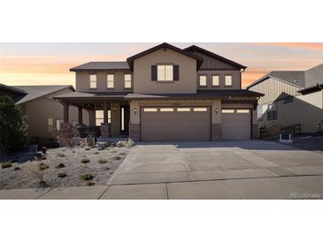 Charming two-story home with a three-car garage and covered porch at 18984 W 85Th Blf, Arvada, CO 80007