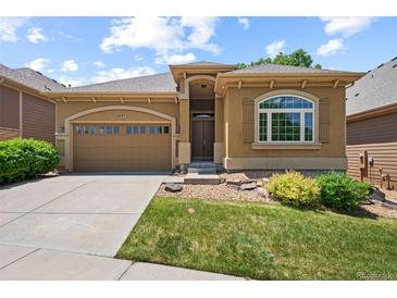 Attractive single-story home featuring a two-car garage, arched window and manicured lawn at 11645 Colony Loop, Parker, CO 80138