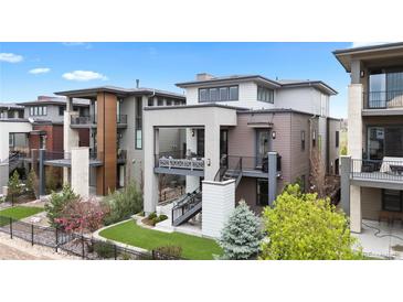 Modern three-story home with outdoor balconies, manicured lawn, and professional landscaping at 10113 Bellwether Ln, Lone Tree, CO 80124