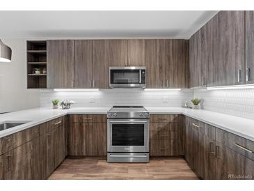 Modern kitchen with stainless steel appliances, sleek cabinets, white countertops and wood flooring at 20 Wilcox St # 318, Castle Rock, CO 80104