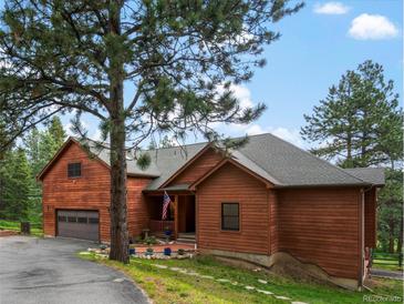 Inviting exterior view of the home featuring a beautiful yard and wood siding at 28465 Cragmont Dr, Evergreen, CO 80439
