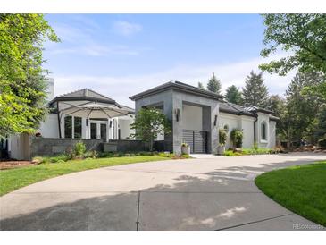 Elegant home with a circular driveway, gray stone portico, and manicured landscaping at 96 Glenmoor Ln, Cherry Hills Village, CO 80113