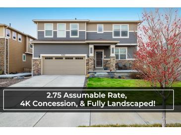 Charming two-story home featuring stone accents, a well-manicured lawn, and a two-car garage at 9283 Sedalia St, Commerce City, CO 80022
