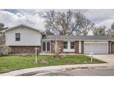 Charming split-level home with brick and siding, a well-manicured lawn, and an attached garage at 7791 S Columbine St, Centennial, CO 80122