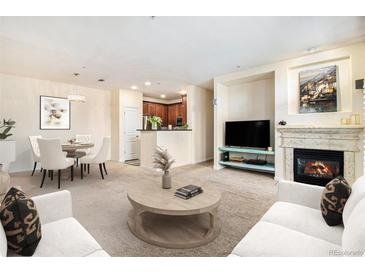 Cozy living room featuring a fireplace, comfortable seating, and an open floor plan to the kitchen and dining area at 8039 Lee Dr # 2, Arvada, CO 80005