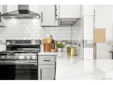 Bright kitchen featuring stainless steel appliances, white cabinetry, and white subway tile backsplash at 11710 Spruce Canyon Cir, Golden, CO 80403