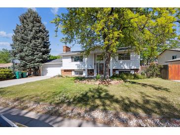 Charming two-story home with a well-manicured lawn and mature trees at 848 S 13Th Ave, Brighton, CO 80601