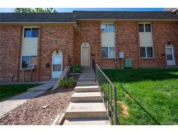 Charming brick townhome with well-maintained lawn and welcoming front entrance with concrete stairs at 4673 S Lowell Blvd, Denver, CO 80236