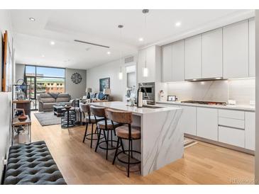 Open-concept kitchen with island, modern appliances, and sleek cabinets flows into the living area at 1901 Wazee St # 504, Denver, CO 80202