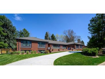 Beautiful brick home with a well-manicured lawn and curved driveway at 4031 S Hudson Way, Cherry Hills Village, CO 80113