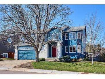 Charming two-story home featuring a red door, blue siding, an attached garage, and a well-maintained lawn at 4175 S Andes St, Aurora, CO 80013