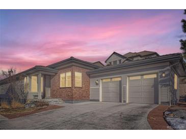 Charming home exterior with brick accents and a spacious two-car garage, perfect for suburban living at 10526 Fairhurst Way, Highlands Ranch, CO 80126