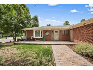 Charming brick home featuring a well-maintained lawn, cozy porch, and decorative wreath at 5490 E Kentucky Ave, Denver, CO 80246