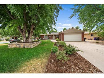 Charming brick ranch home with attached garage, lush landscaping, and mature shade tree at 5490 E Kentucky Ave, Denver, CO 80246