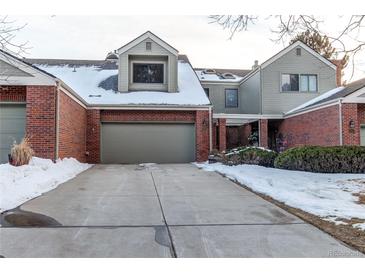 Brick townhouse exterior with snow covered driveway and landscaping at 8855 Green Meadows Dr, Highlands Ranch, CO 80126