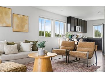 Bright living room featuring modern furnishings and decor with large windows providing natural light at 18645 E 54Th Pl, Denver, CO 80249