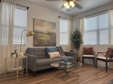 Bright living room featuring modern decor and a large window offering natural light at 9756 Ash Ln, Thornton, CO 80229