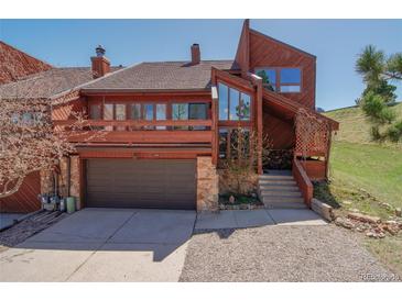 Inviting two-story home featuring a two-car garage, balcony, and stone accents at 4484 Juniper Ct, Larkspur, CO 80118