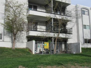 Apartment building featuring balconies and secure gated patio on the ground floor at 2325 S Linden Ct # 101, Denver, CO 80222