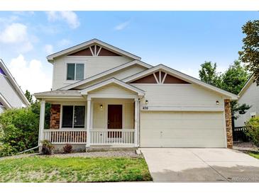 Two-story house with a beige exterior, attached garage, and front porch at 470 Grey Swallow St, Brighton, CO 80601