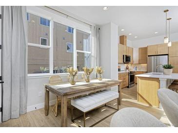 Bright dining area with a wooden table, stylish bench, large windows, and seamless flow into the modern kitchen at 2855 S Pancratia St, Denver, CO 80236