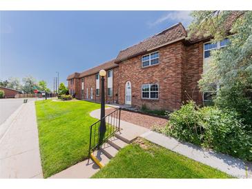 Charming brick townhome featuring a well-manicured lawn and inviting entryway at 3608 W Radcliff Ave, Denver, CO 80236