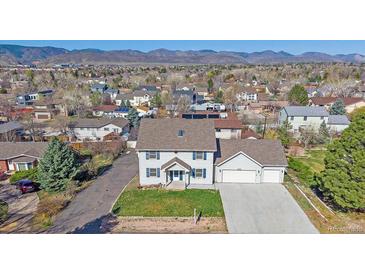 Inviting two-story home boasts a well-manicured lawn and an attached two-car garage at 8225 S Cody St, Littleton, CO 80128