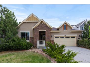 Charming two-story home featuring a well-manicured lawn, brick accents, and an attached two-car garage at 17223 W 84Th Dr, Arvada, CO 80007