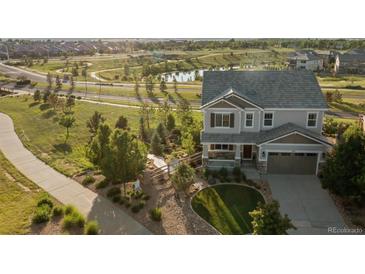 Charming two-story home with manicured lawn, complemented by lush greenery and a tranquil pond view at 3741 Harvard Pl, Broomfield, CO 80023