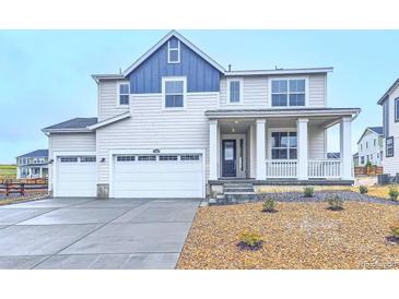 Charming two-story home featuring a three-car garage, front porch, and landscaped yard at 39857 Floyd St, Elizabeth, CO 80107