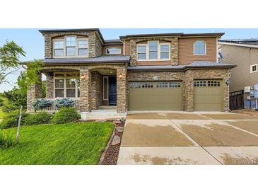 Two-story home featuring a stone and siding exterior, a well-manicured lawn, and a two-car garage at 1648 Exquisite St, Castle Rock, CO 80109