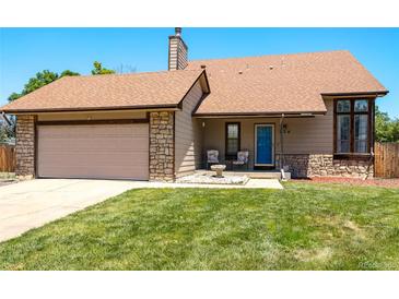 Charming single-story home featuring a well-maintained lawn, inviting entrance and an attached garage with stone accents at 750 S Dearborn Ct, Aurora, CO 80012