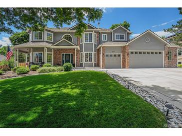 Charming two-story home boasts a well-manicured lawn, a three-car garage, and attractive brick accents at 4541 Christensen Cir, Littleton, CO 80123