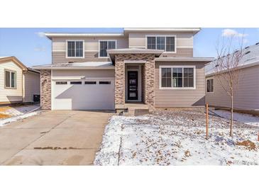 Beautiful two-story home featuring stone accents, a two-car garage, and neutral color palette at 9122 Telluride Ct, Commerce City, CO 80022