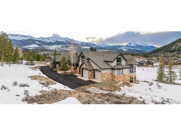 Stunning mountain home featuring stone accents, a three-car garage, and breathtaking snowy mountain views at 174 Sage Dr, Breckenridge, CO 80424
