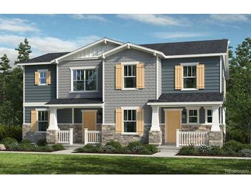 Charming townhome featuring stone accents, a covered porch, and eye-catching shutters at 20740 E 58Th Ave, Aurora, CO 80019