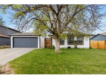 Charming home featuring lush green lawn and mature trees in a well-maintained front yard at 720 Independence Dr, Longmont, CO 80504