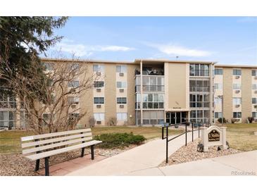 A tan condo building with 3 stories and well-maintained landscaping at 13606 E Bates Ave # 309, Aurora, CO 80014