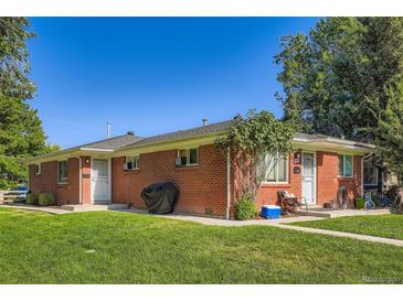Charming brick duplex with a well-maintained lawn and mature trees under a clear blue sky at 2495 S Race St, Denver, CO 80210