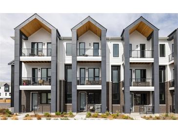 Modern townhome exterior featuring balconies, sleek gray accents, and contemporary design at 8280 E 36Th Ave # 26, Denver, CO 80238