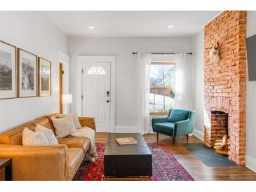 Bright living room with a decorative brick fireplace and comfortable, stylish furniture at 3534 Decatur St, Denver, CO 80211