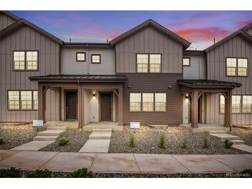 Charming townhomes featuring board and batten siding and inviting covered front porches, great for enjoying peaceful evenings at 16774 W 93Rd Pl, Arvada, CO 80007