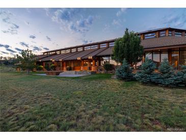 Expansive home exterior featuring an architectural design, large lawn, and inviting outdoor space at 6455 Dakota Ridge Dr, Golden, CO 80403
