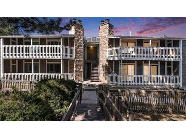 Inviting condo building with charming stone accents and private balconies at sunset at 18106 E Ohio Ave # 103, Aurora, CO 80017