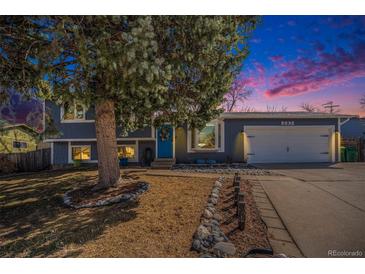 Charming home featuring a blue exterior and a mature tree in the front yard and a blue door at 6532 S Field Way, Littleton, CO 80123