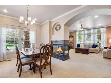 Bright living room with fireplace, large windows, and neutral decor for a cozy and inviting atmosphere at 15501 E 112Th Ave # 33D, Commerce City, CO 80022